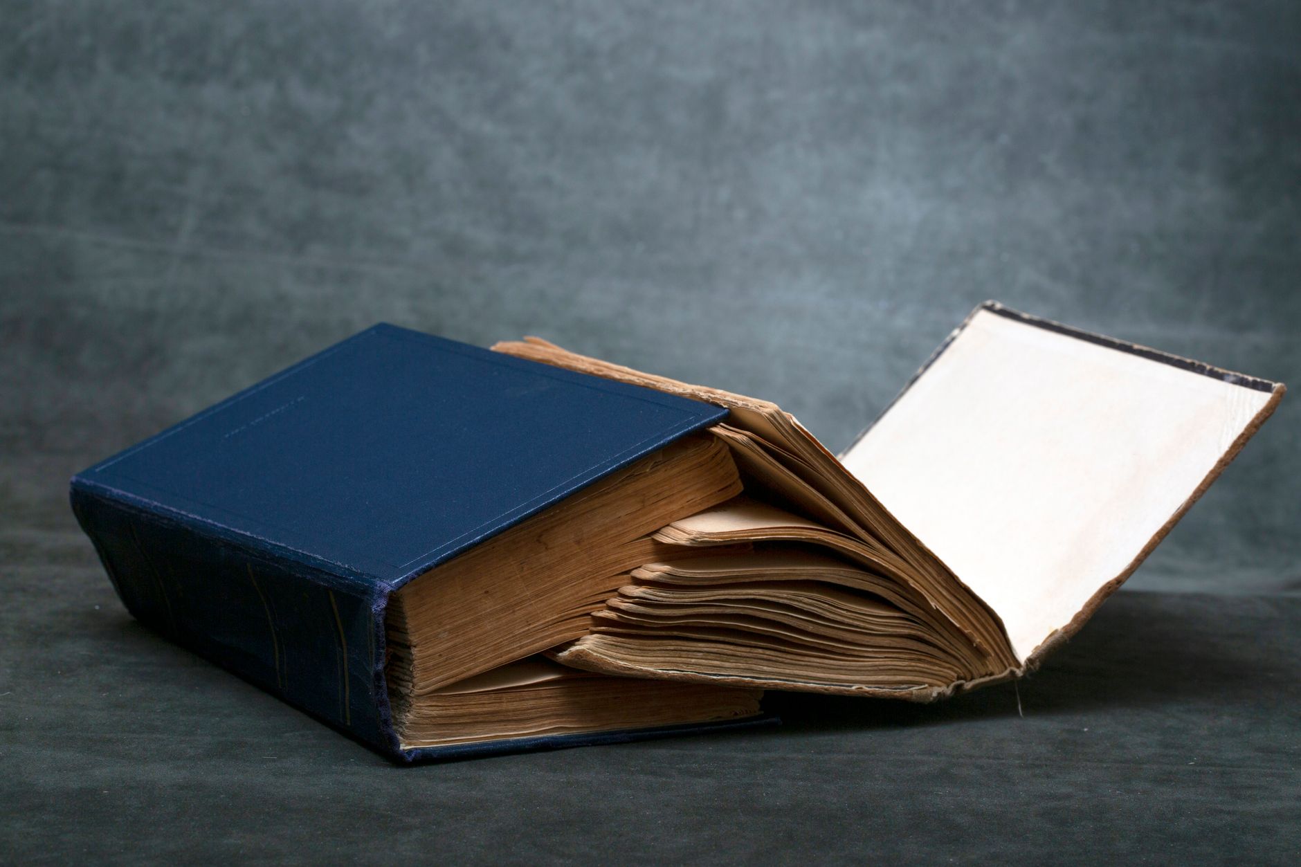 Livro de capa dura aberto sobre uma mesa, com a guarda e as primeiras páginas à vista