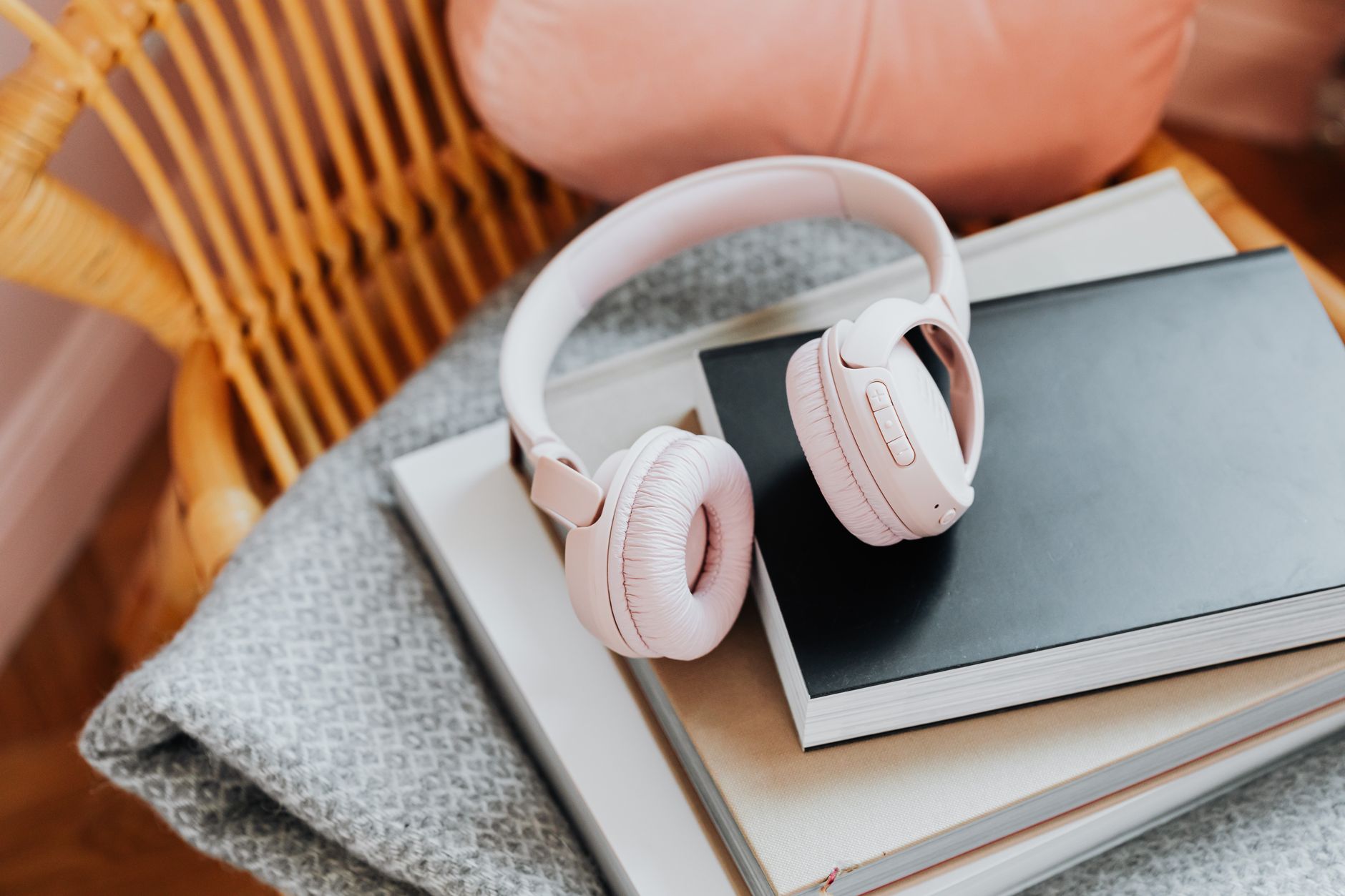 fones de ouvido ao lado de um livro fechado sobre uma mesa