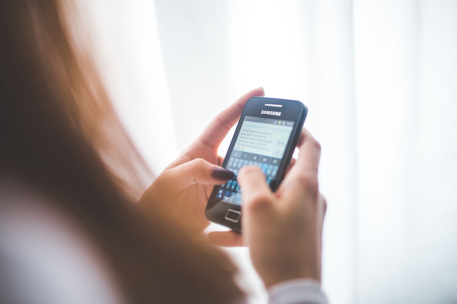 mãos digitando um texto em um celular