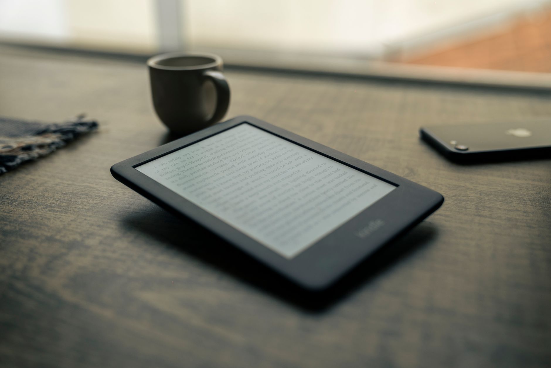 E-reader com uma página de texto aberta sobre uma mesa