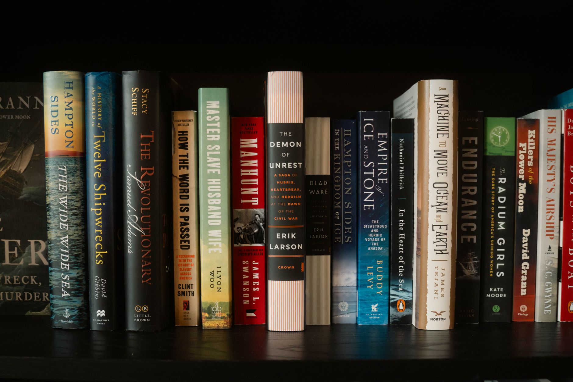 Estante com livros de espessuras e alturas diferentes lado a lado