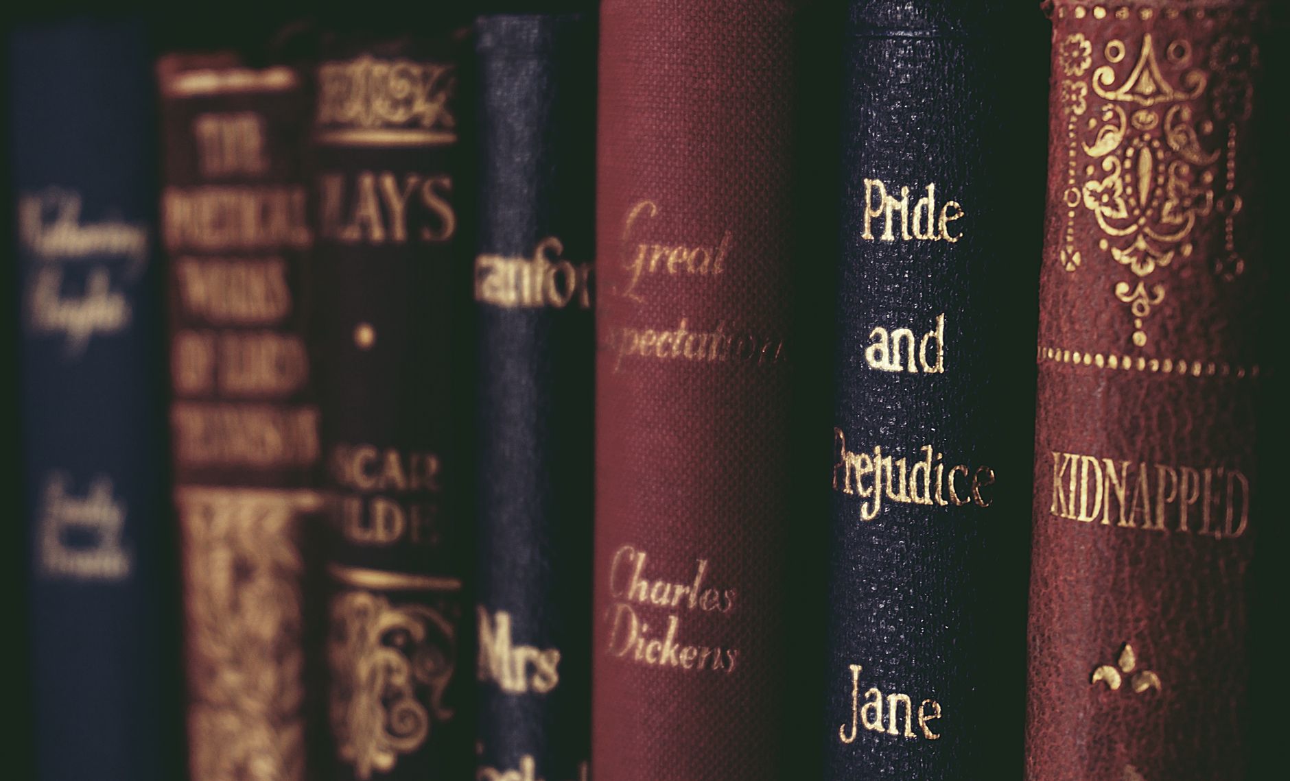 Estante com fileira de livros clássicos de lombadas variadas