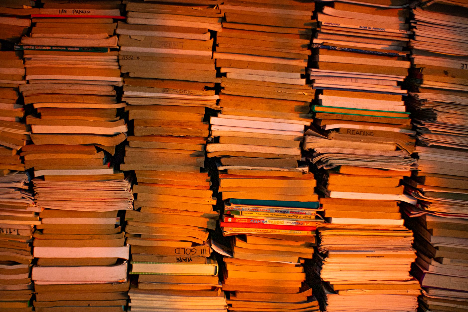 Pilha de livros de bolso sobre uma mesa de madeira