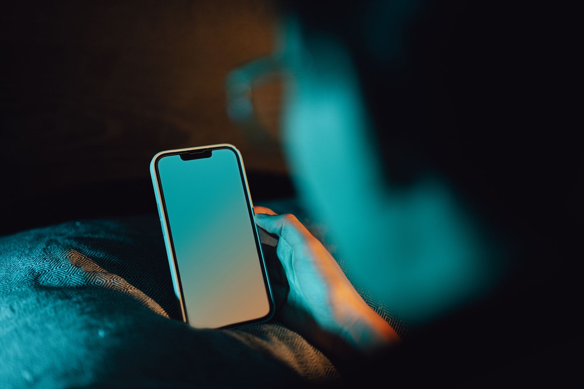 mãos segurando um celular aceso, em leitura