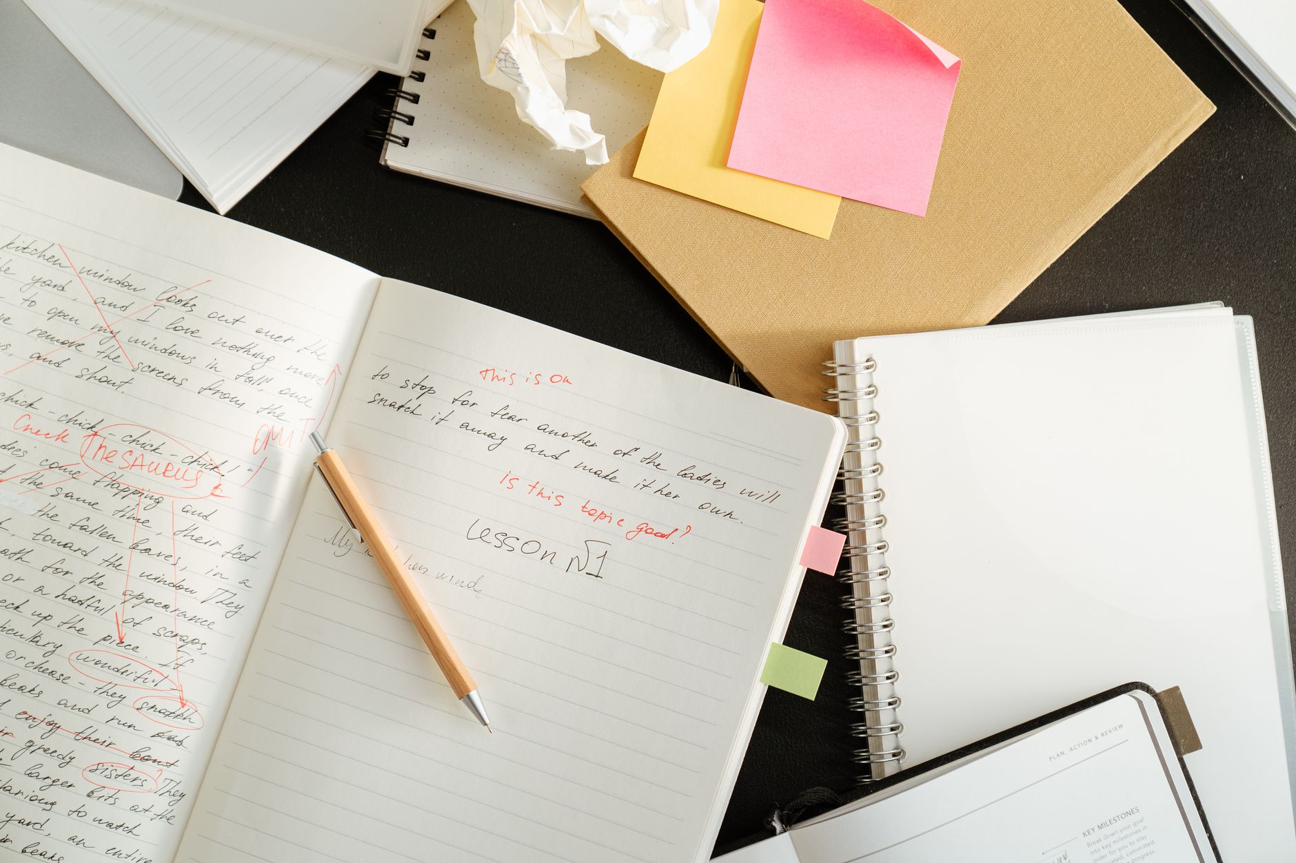 post-its e um bloco de notas com rabiscos sobre uma mesa