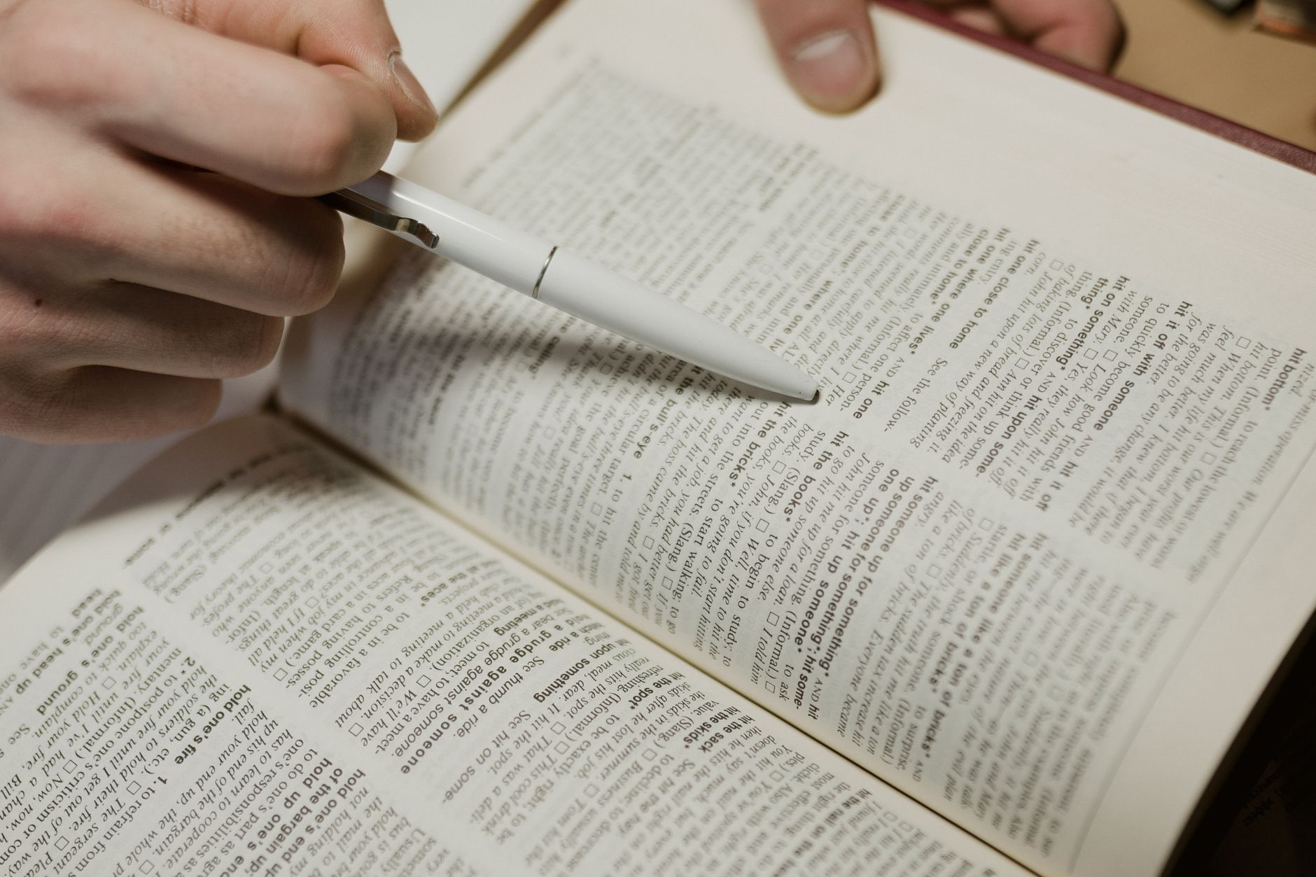 livro aberto com um lápis apontando para uma frase