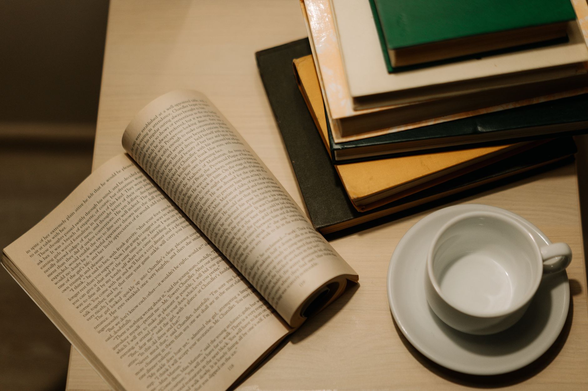 pilha de livros brochura sobre uma mesa de madeira