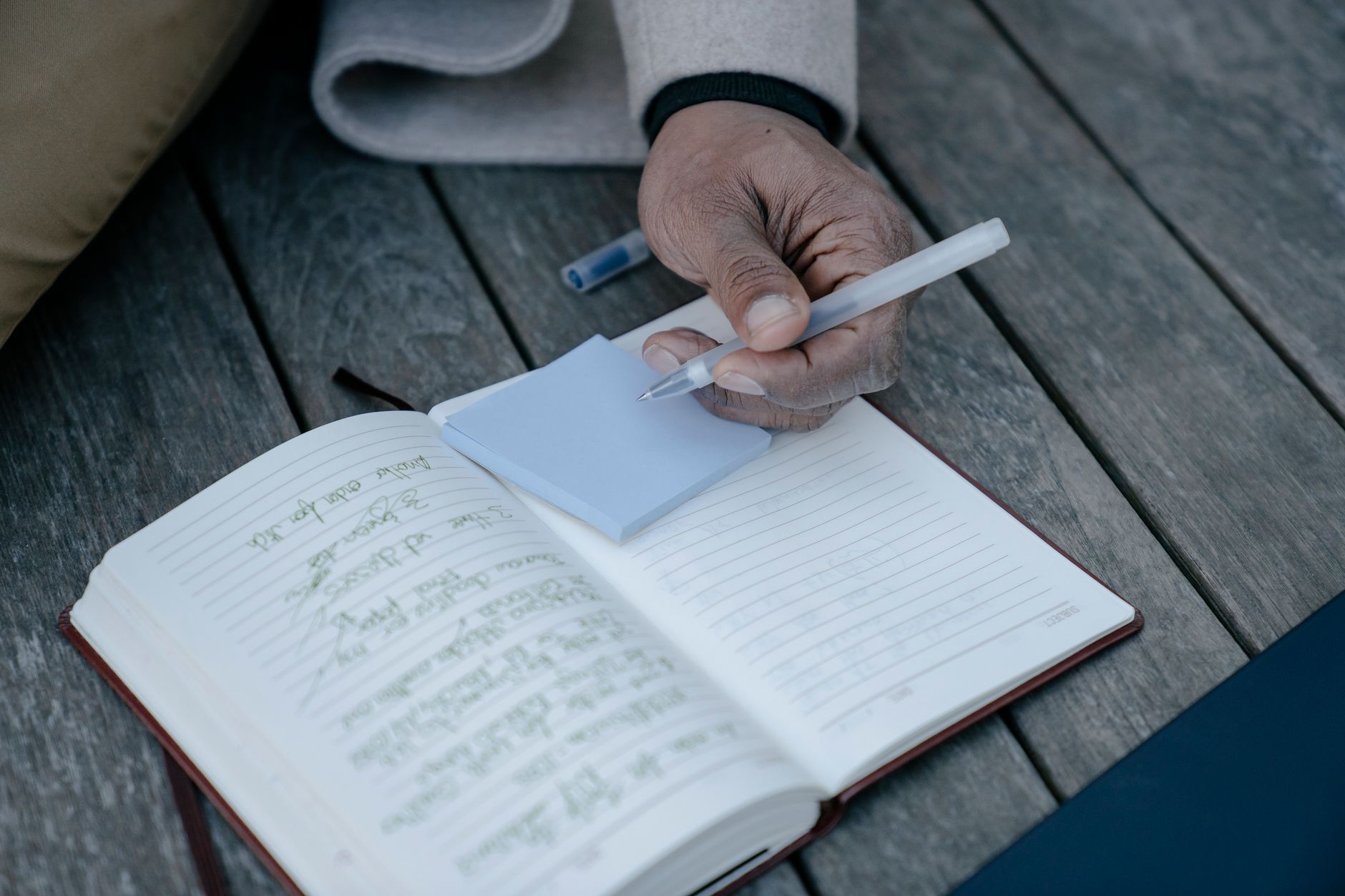 Caderno aberto com uma lista manuscrita de anotações e uma caneta ao lado.