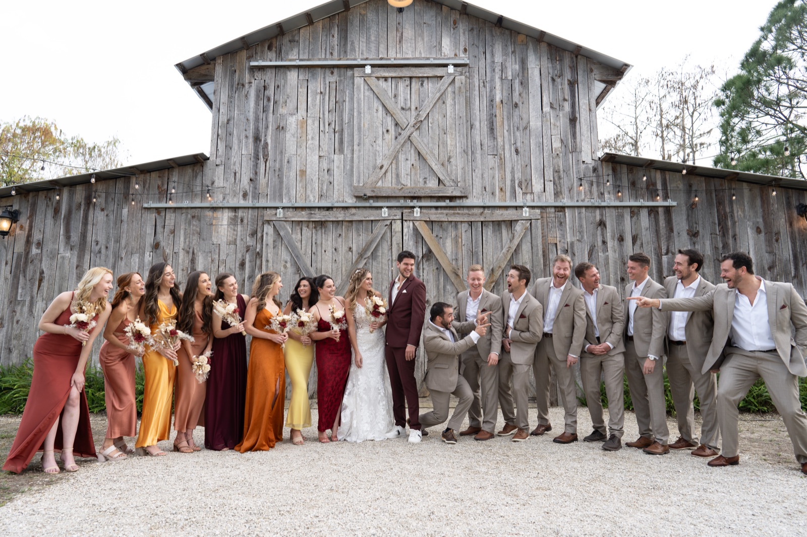 Kelli and Bradley's bridal party laughing and celebrating in front of Misty Morning Barn