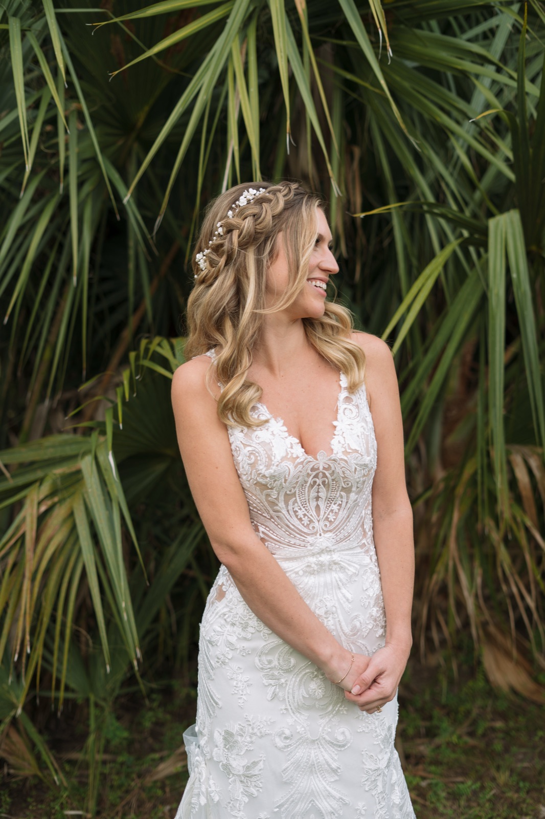 Bride Kelli portrait showing braided crown hairstyle with delicate floral hair piece and intricate lace wedding gown at Misty Morning Barn