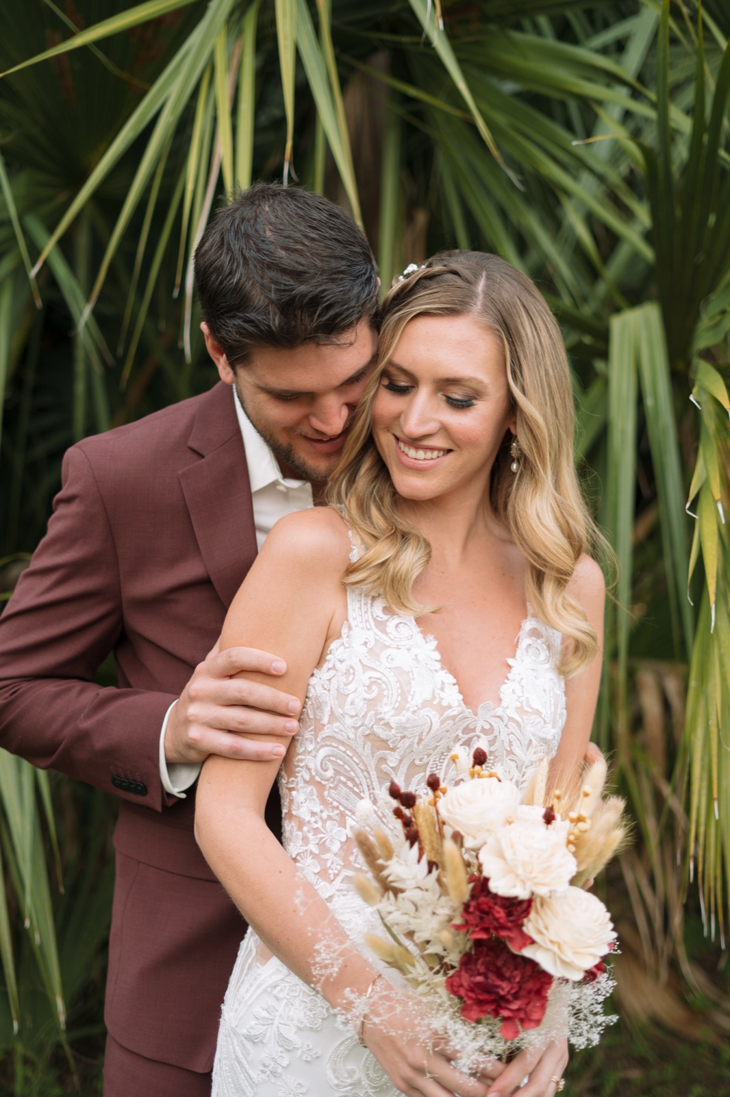 Intimate portrait of Kelli and Bradley, groom nuzzling bride who holds her dried flower bouquet at their Fort Myers barn wedding