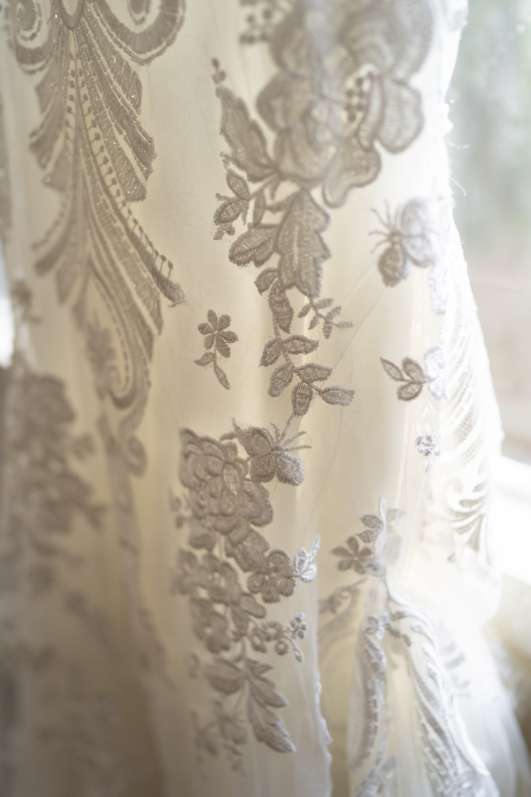 Close-up of intricate lace and embroidery detail on Kelli's wedding dress at Misty Morning Barn