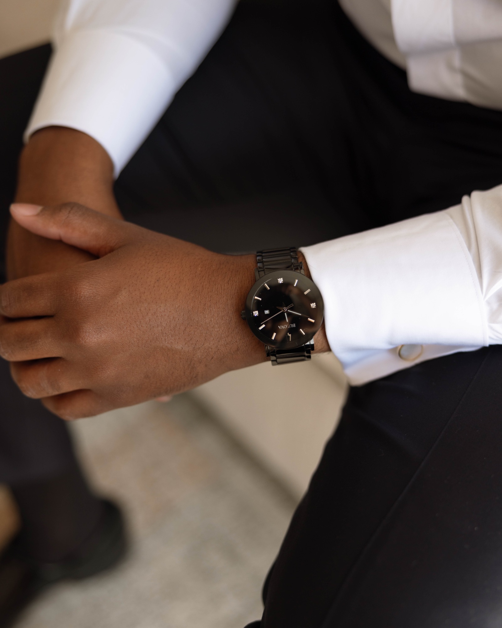 A groomsman helping the groom with his cuff