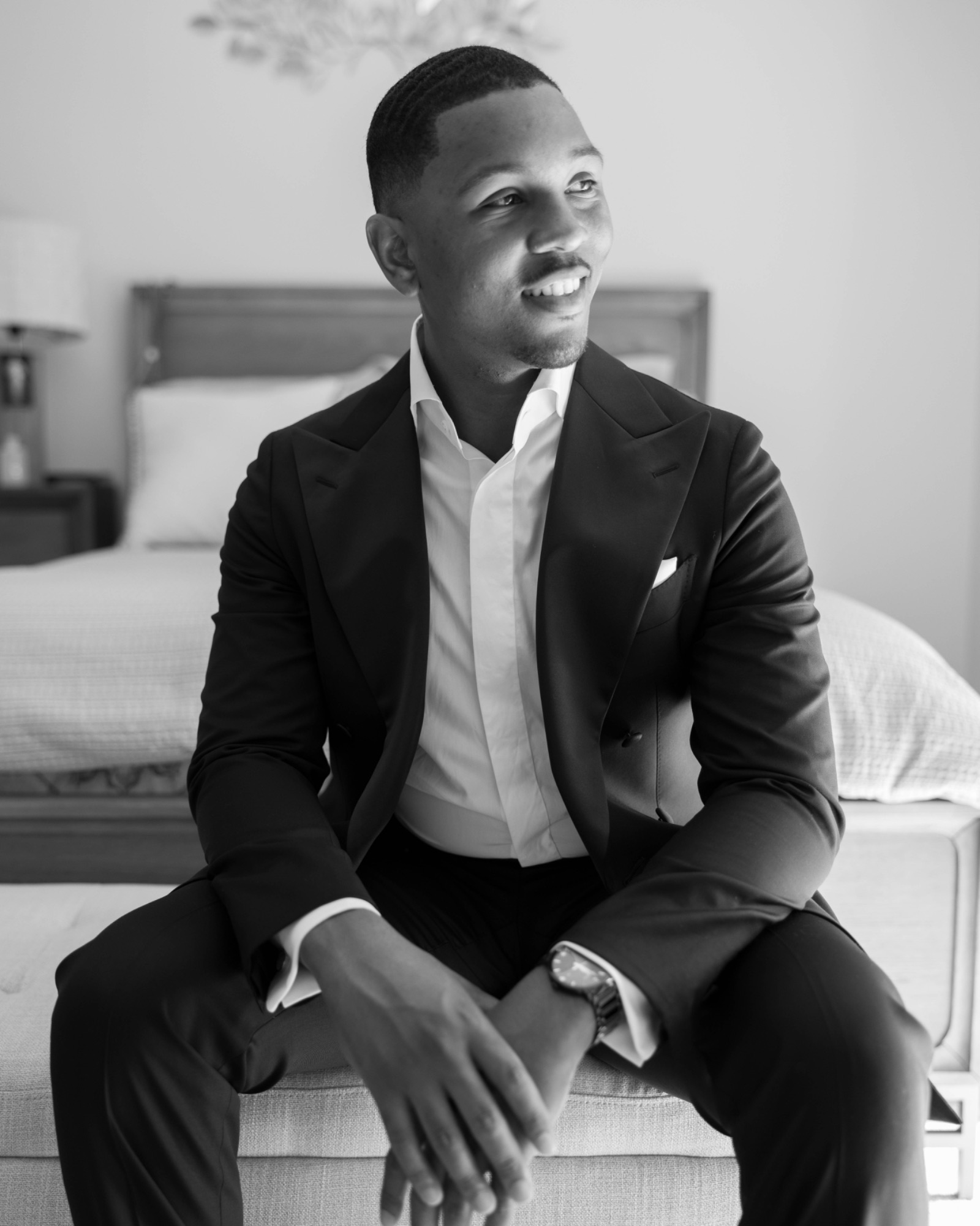 The groom seated in his tuxedo, black and white