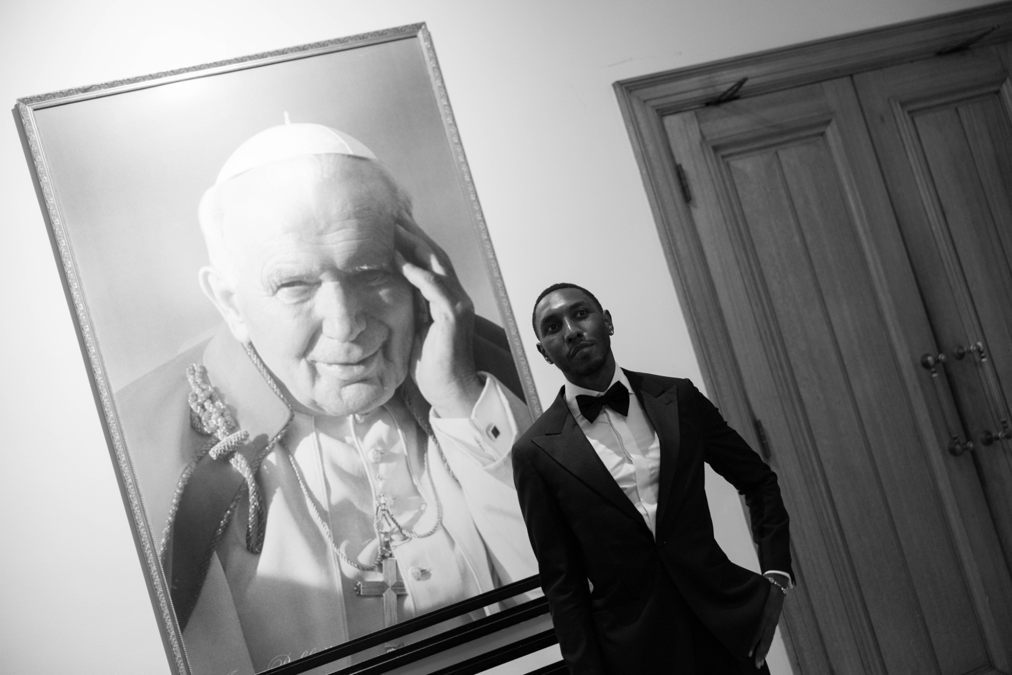 The groom beside a portrait of John Paul II in the church