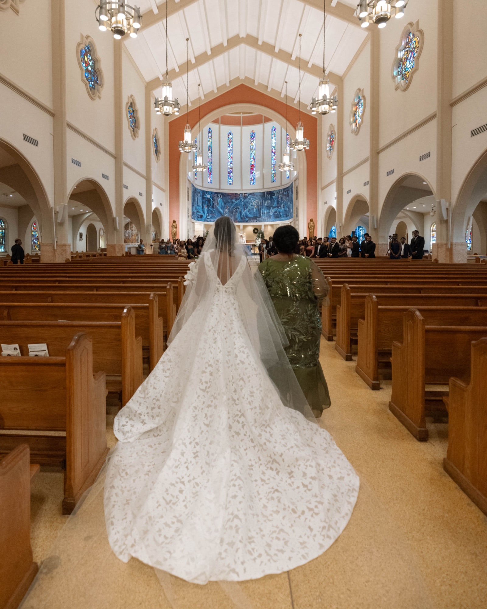 The bride walking the aisle, her cathedral veil trailing behind her