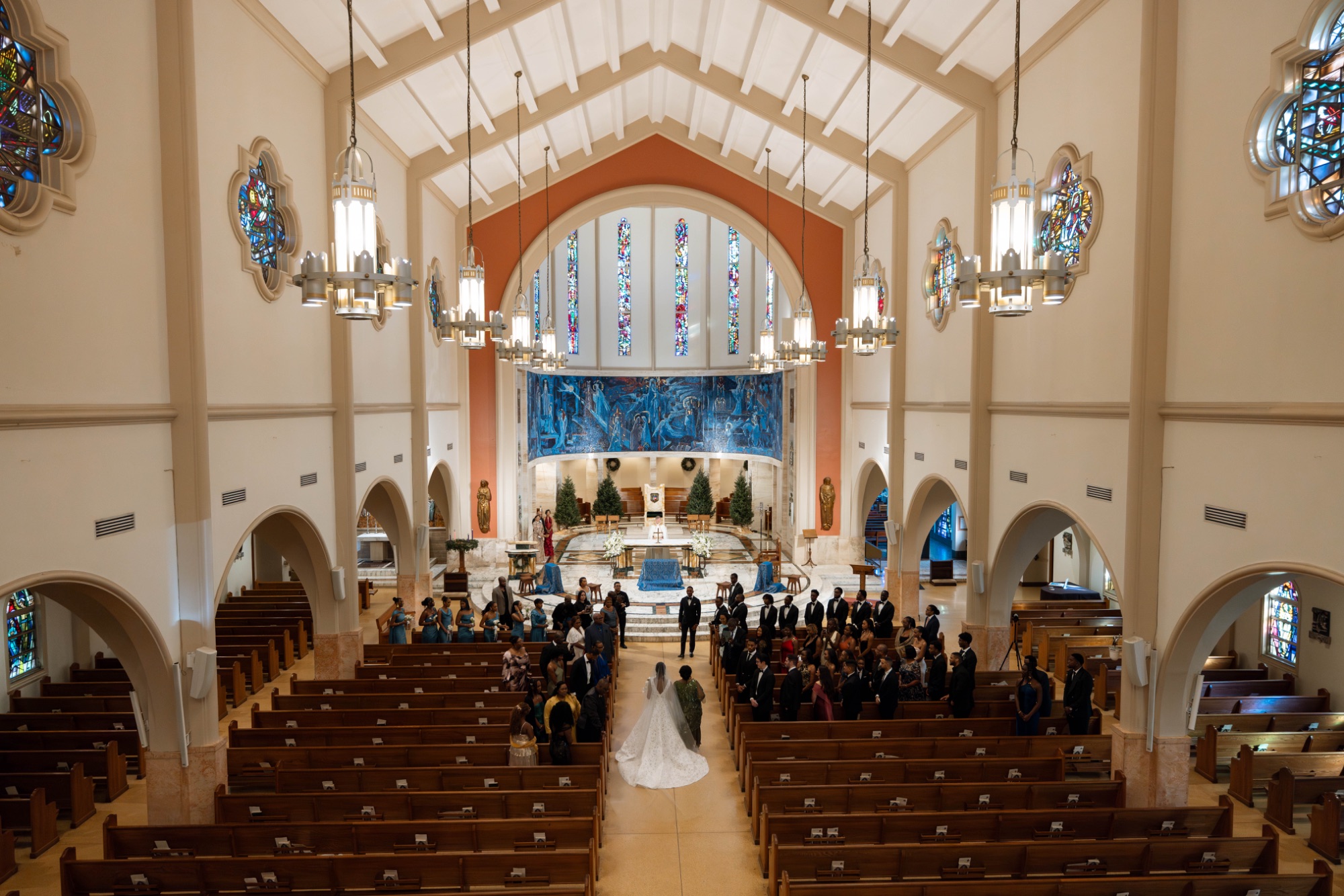 The congregation stands as the couple meet at the altar
