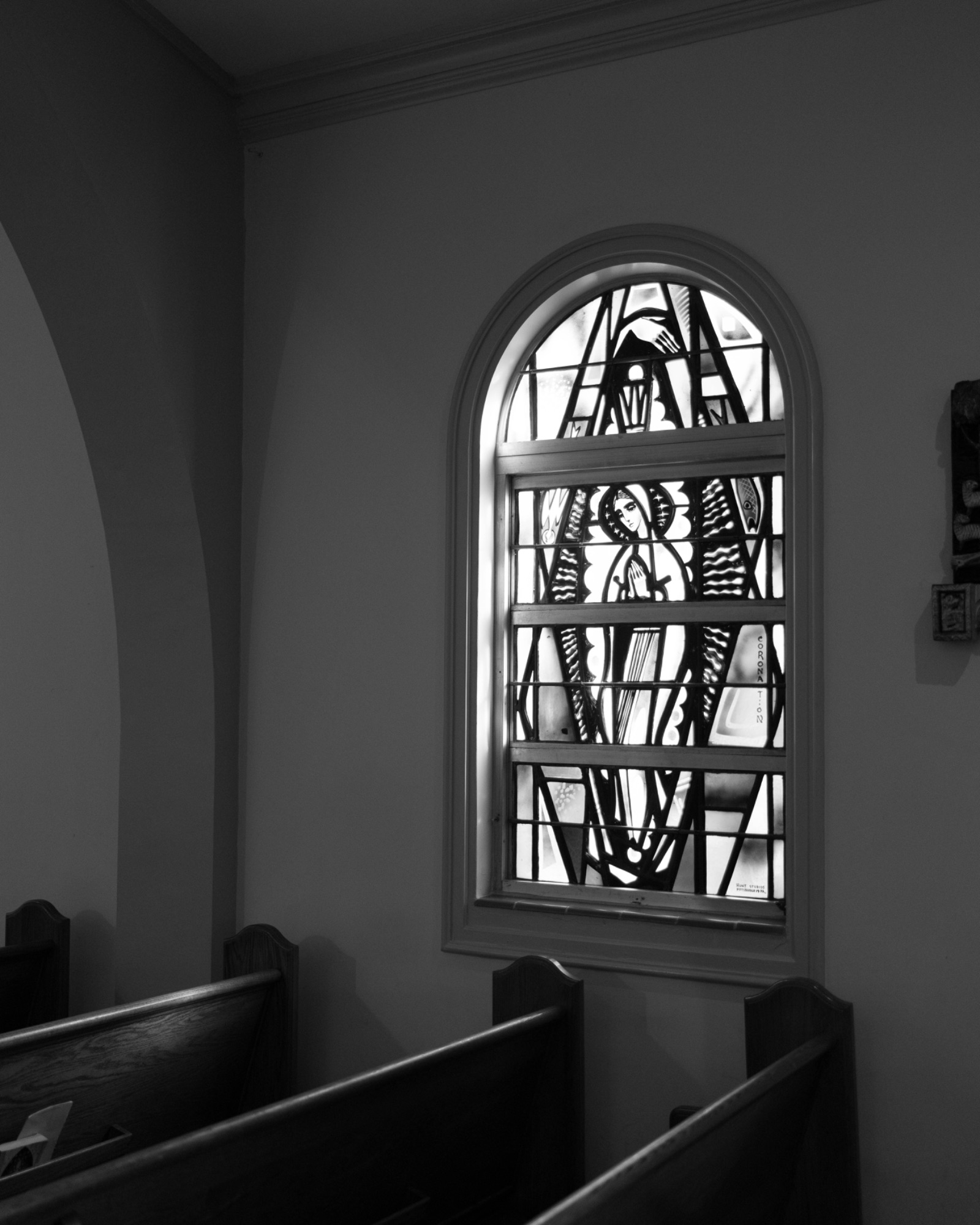 Light through a stained glass window above the pews