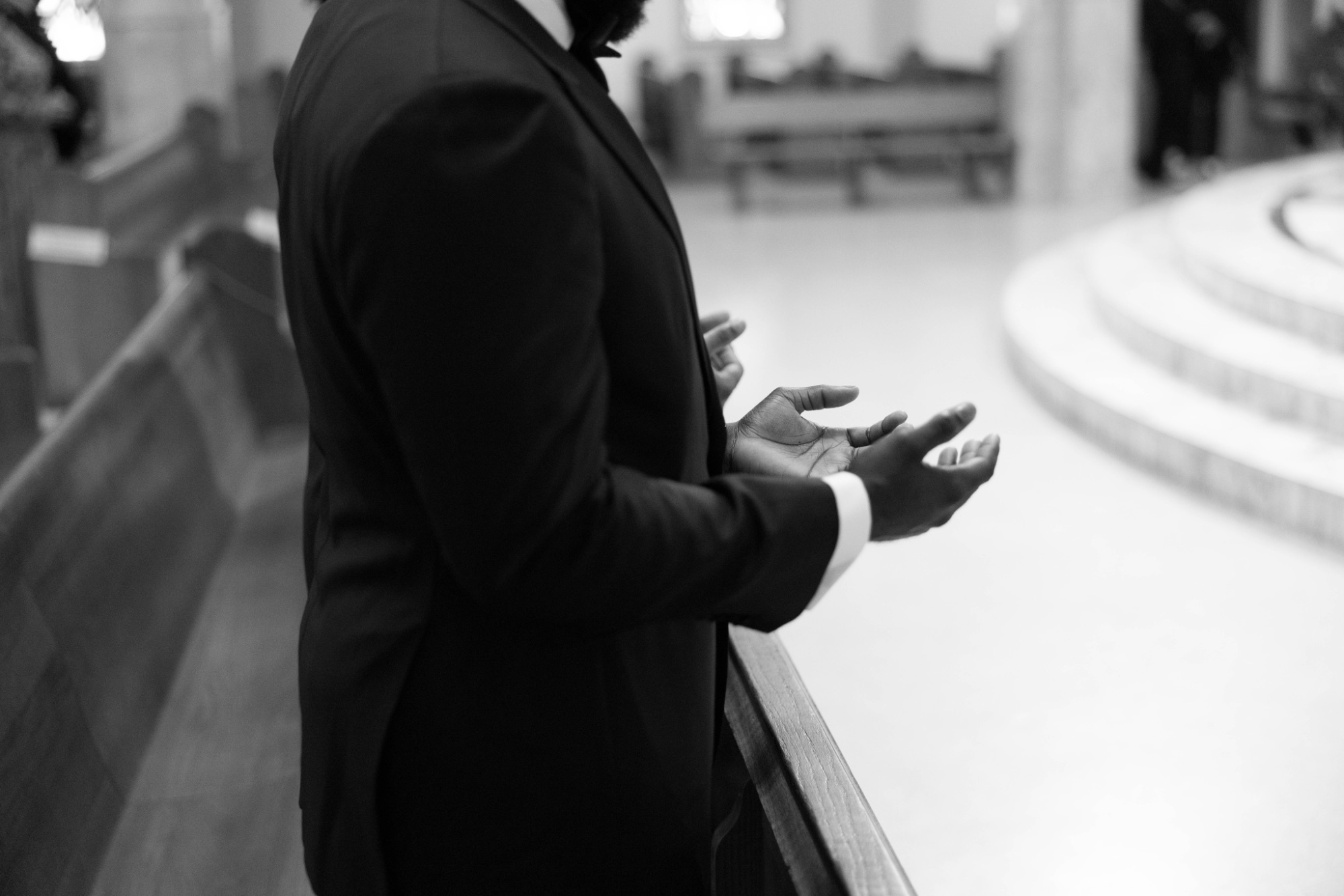 The groom's hands open in prayer during the Mass