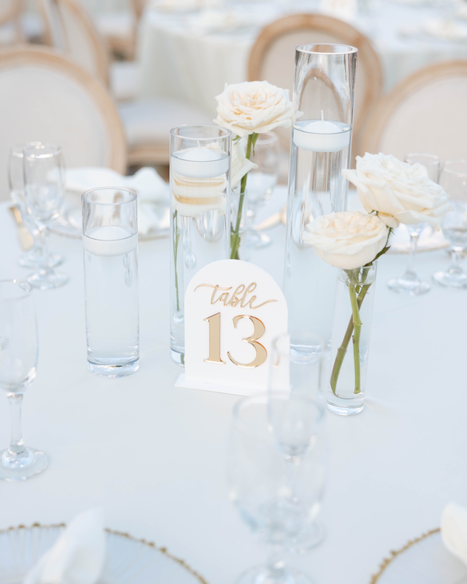 Table thirteen set with white roses and gold-rimmed glassware