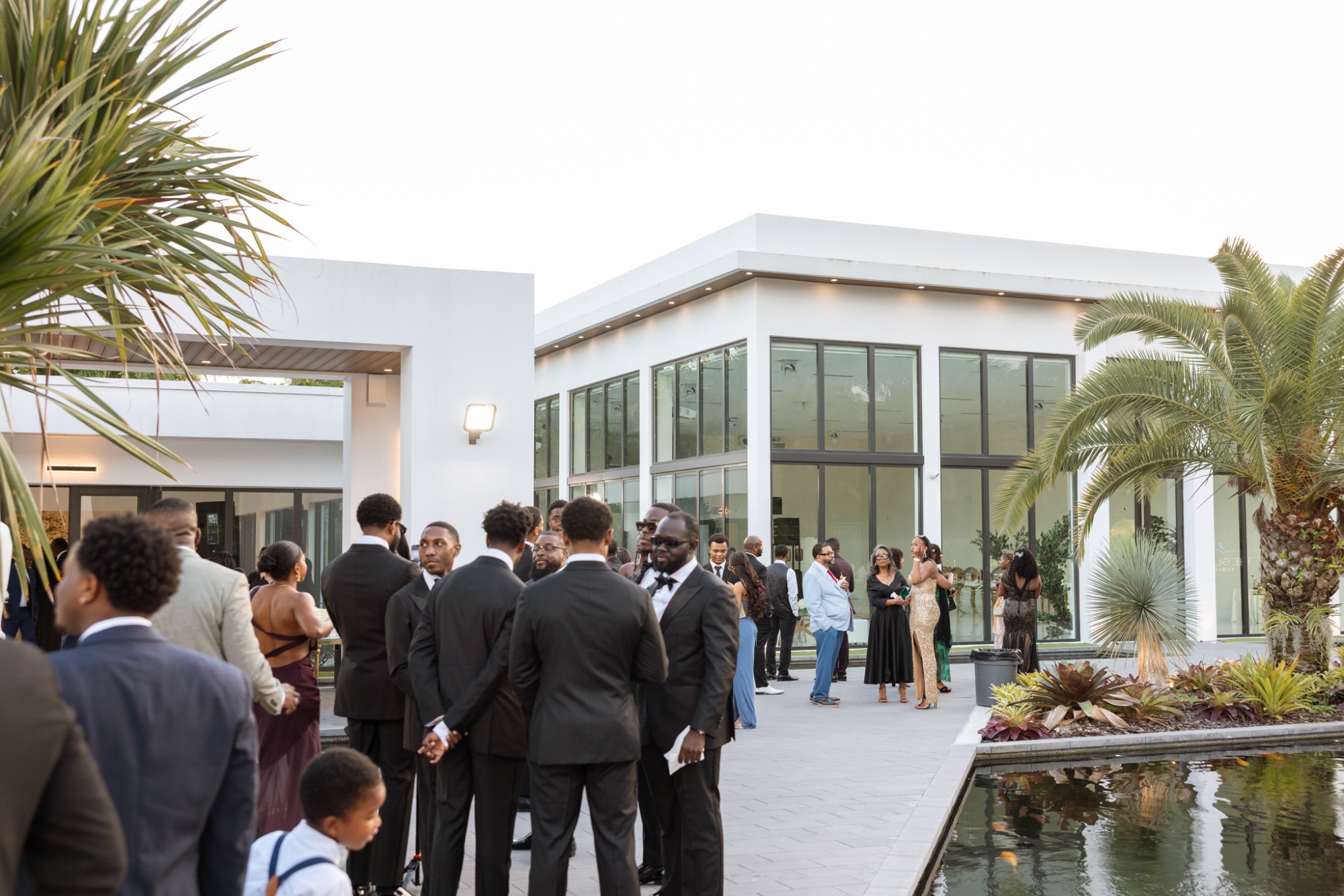 Guests outside the glass reception building by the reflecting pool