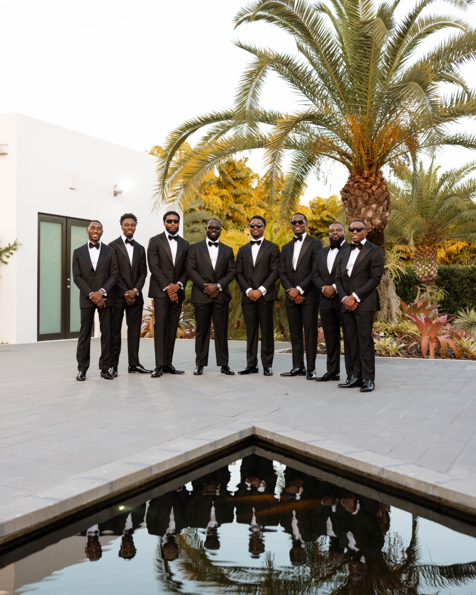 The groomsmen along the reflecting pool at The Glass Venue