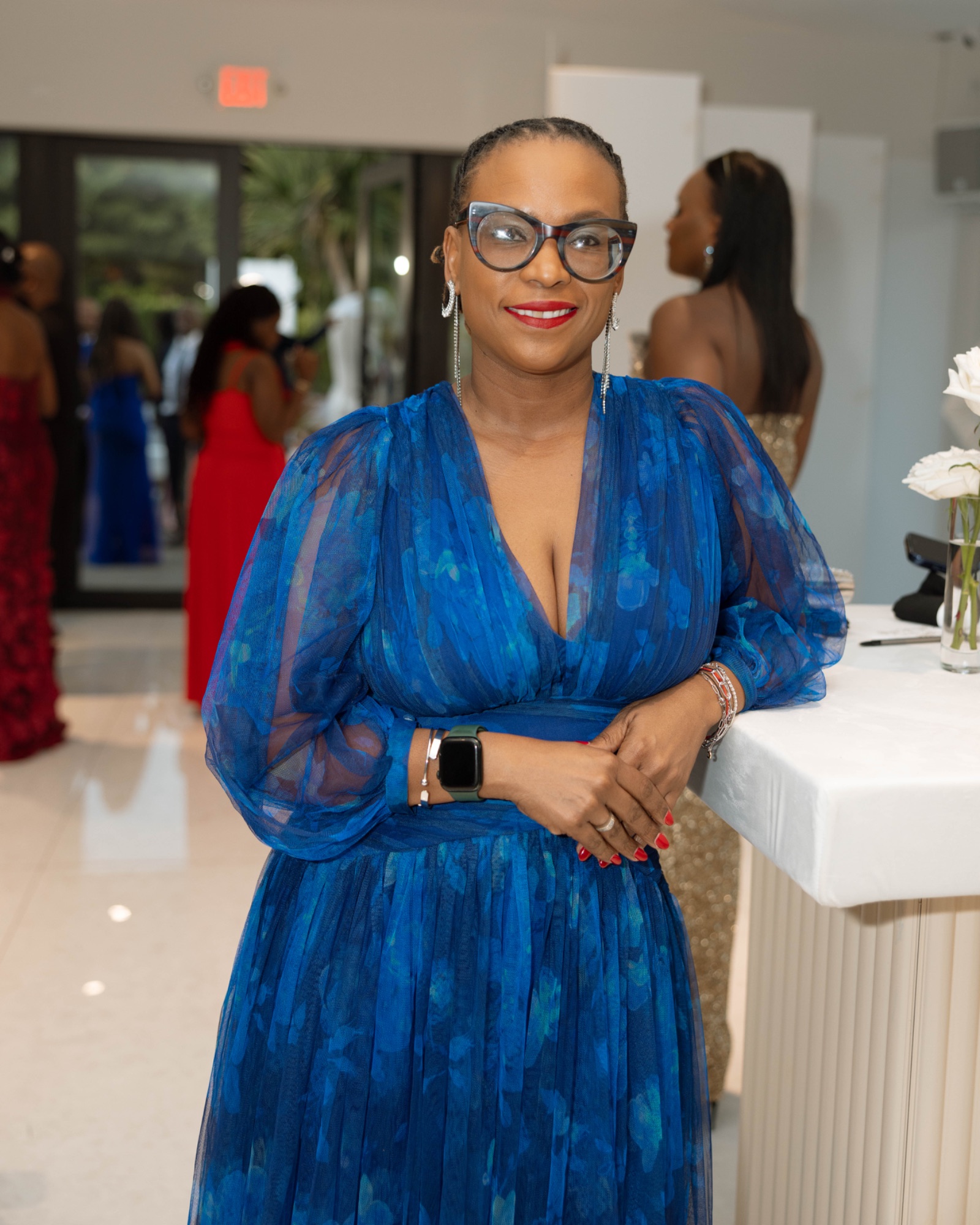 A guest in blue beside the glass wall