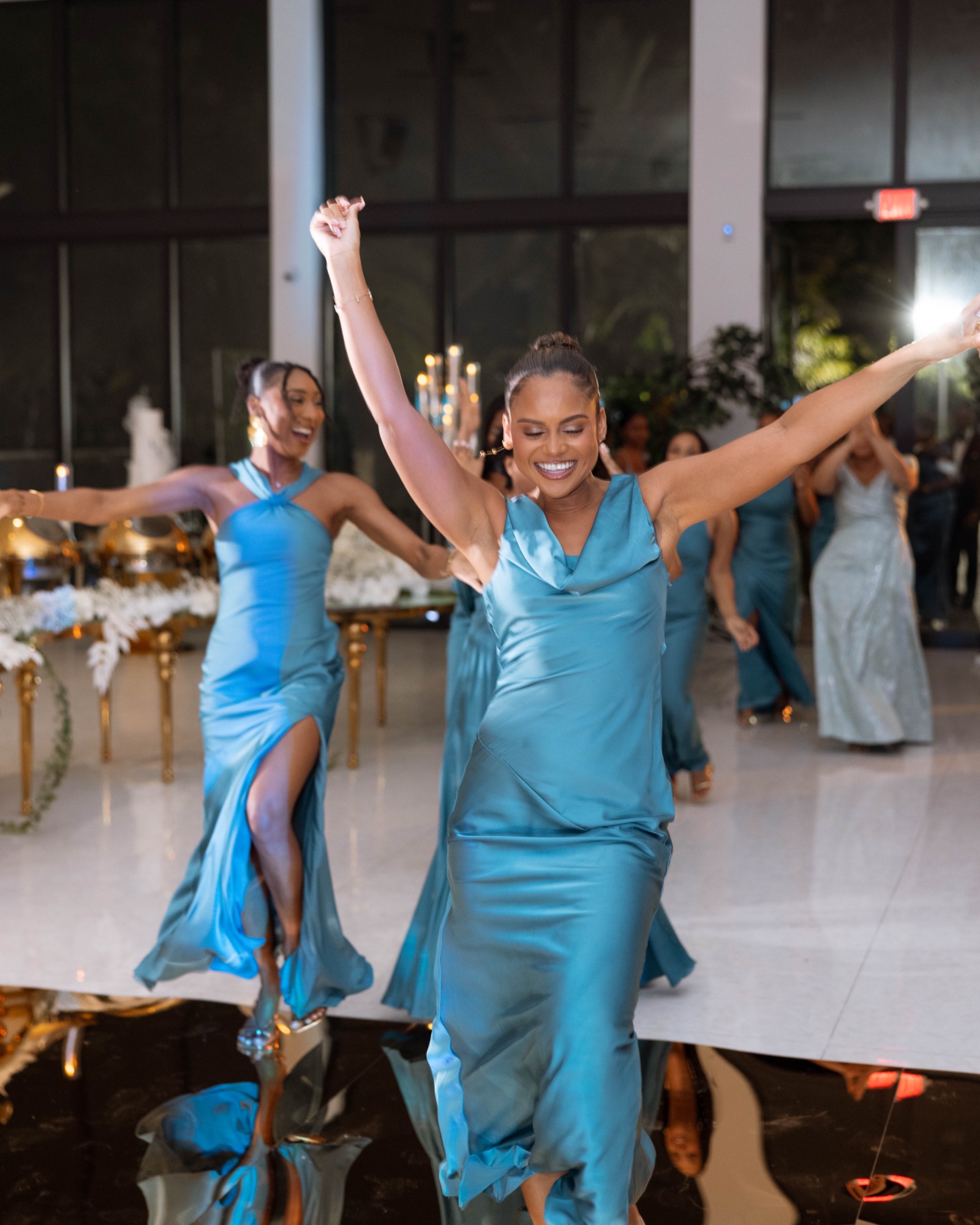 Bridesmaids entering the reception with their arms raised