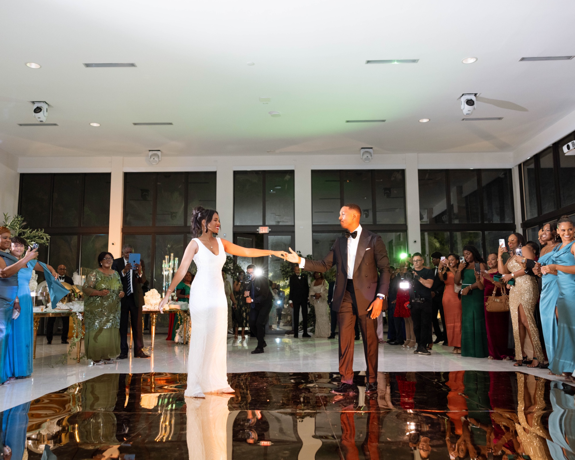 The couple reaching each other on the mirrored dance floor