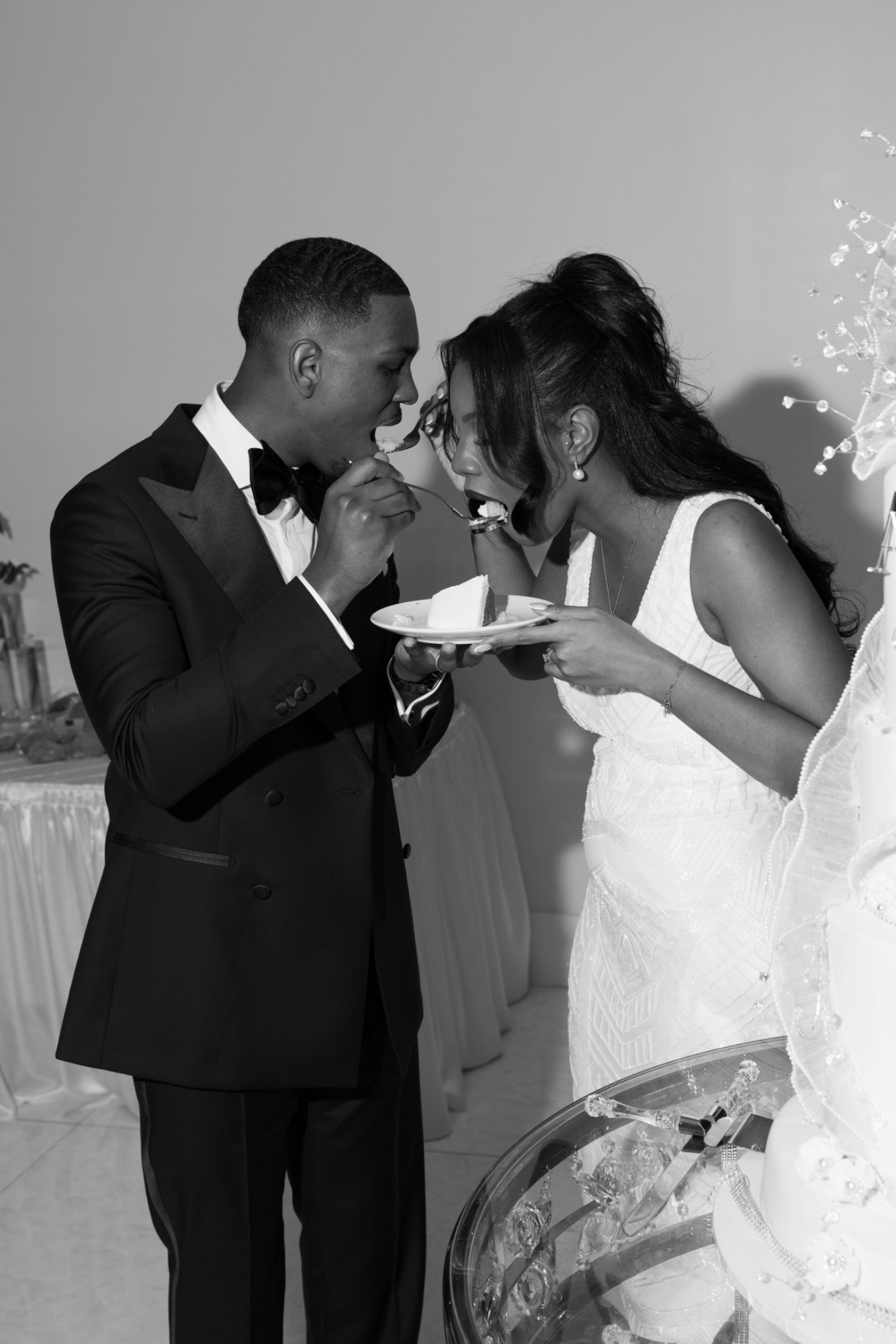 The couple feeding each other cake, black and white
