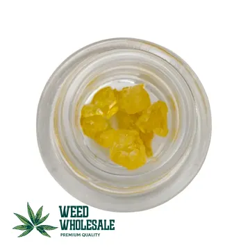 Golden yellow crystals of THC Diamonds – 1G cannabis concentrate in a transparent grass jar