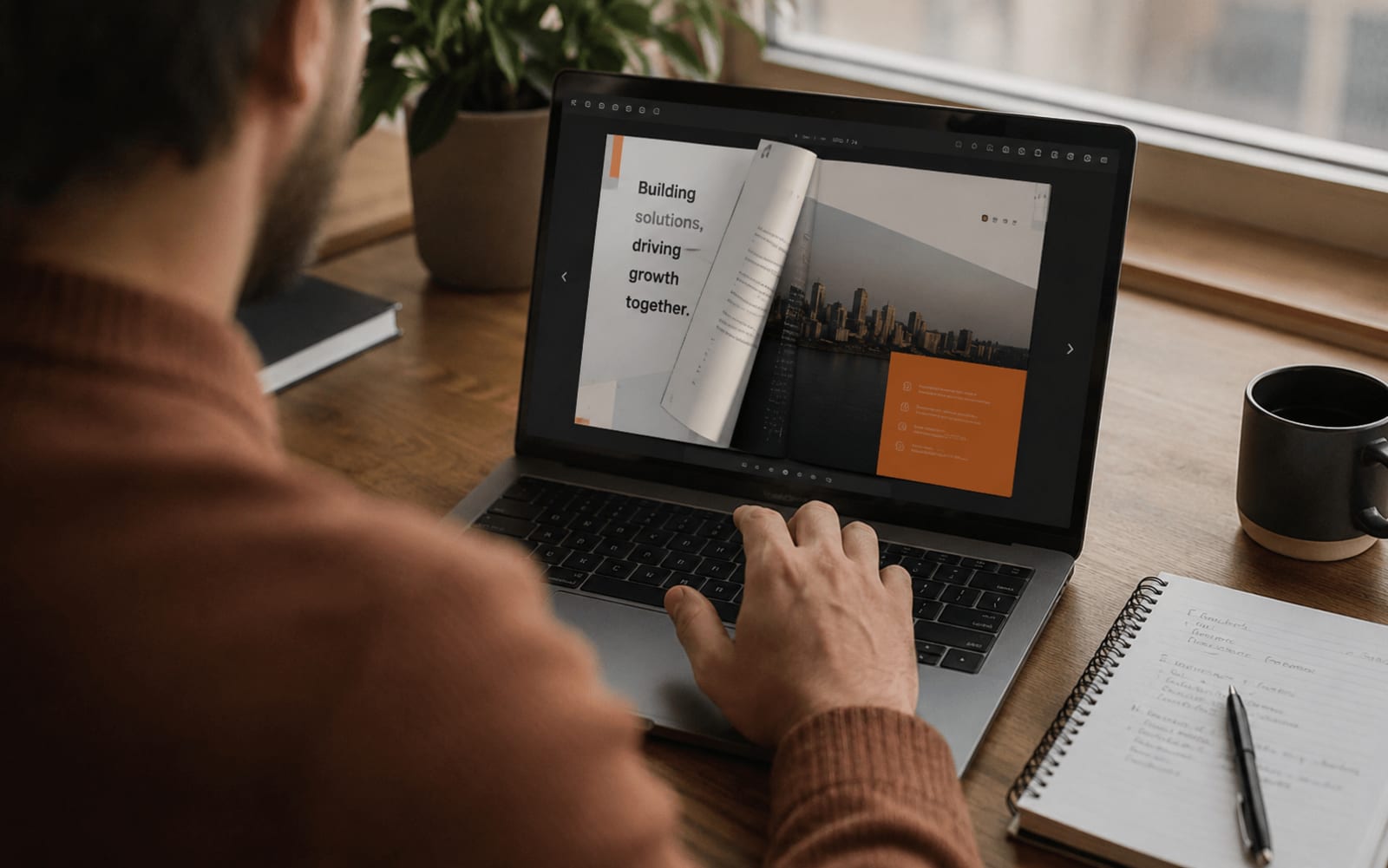 Người dùng lật xem hồ sơ năng lực điện tử dạng flipbook trên laptop, trang đang lật để lộ một spread danh mục dự án