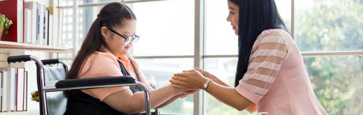 a picture of a support coordinator holding the hands of an individual she's supporting