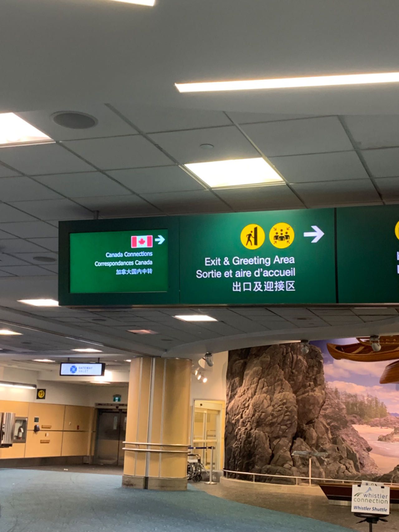 Multilingual guidance screens seen upon successful immigration at Vancouver Airport.