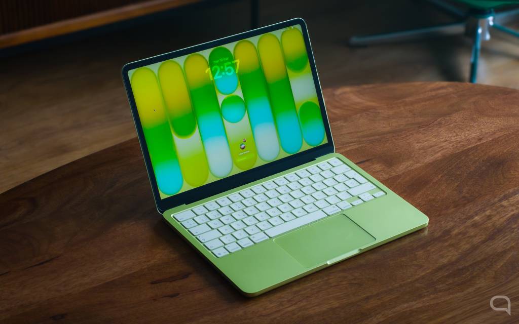 Un MacBook Neo abierto en un escritorio limpio y moderno, mostrando su pantalla brillante y teclado iluminado, con un enfoque suave en el producto.