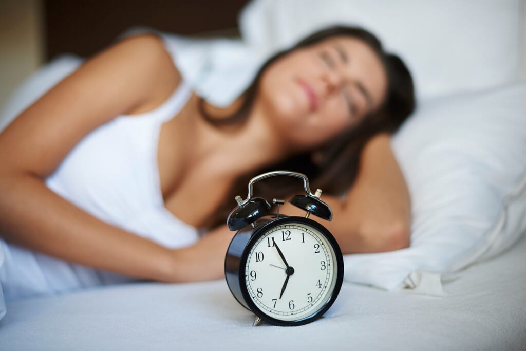 Una persona durmiendo pacíficamente en una cama moderna con luces tenues