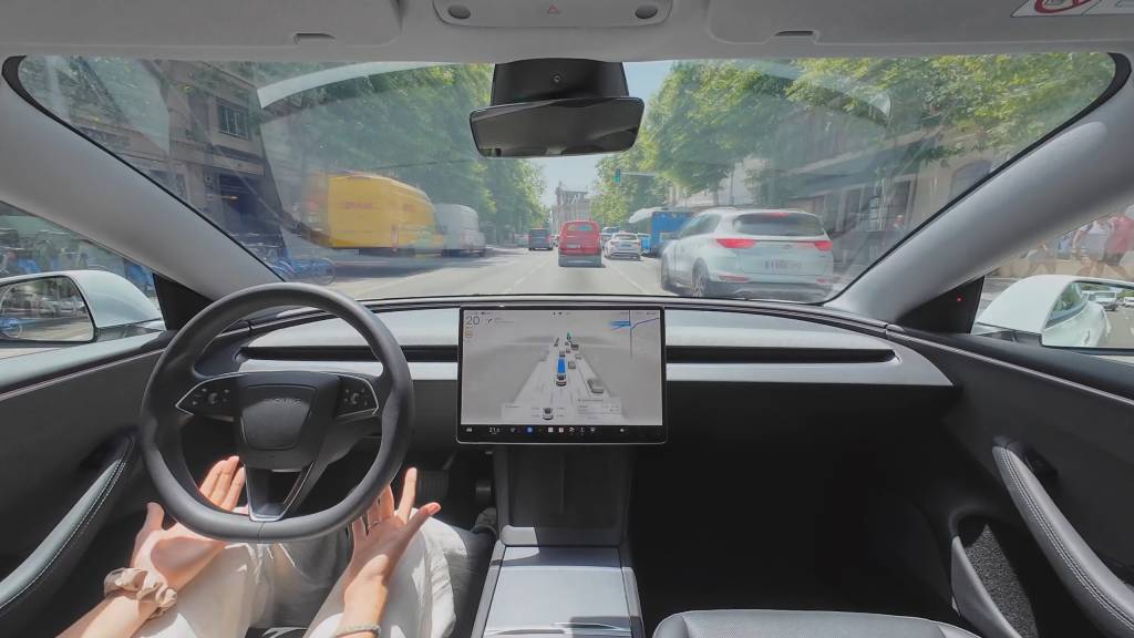 Tesla Model S con luces de conducción autónoma activadas en una carretera europea moderna