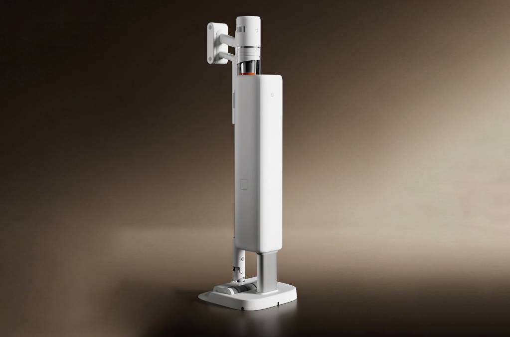 A modern Xiaomi cordless vacuum cleaner with its self-cleaning charging base in a well-lit, contemporary living room.