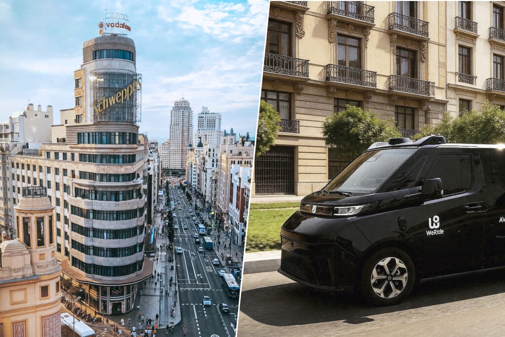 Un robotaxi futurista circulando por una calle de Madrid al anochecer, con luces de neón y edificios modernos.