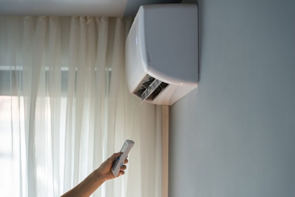 Una persona durmiendo plácidamente con un ventilador de techo encendido suavemente en una habitación oscura y tranquila.