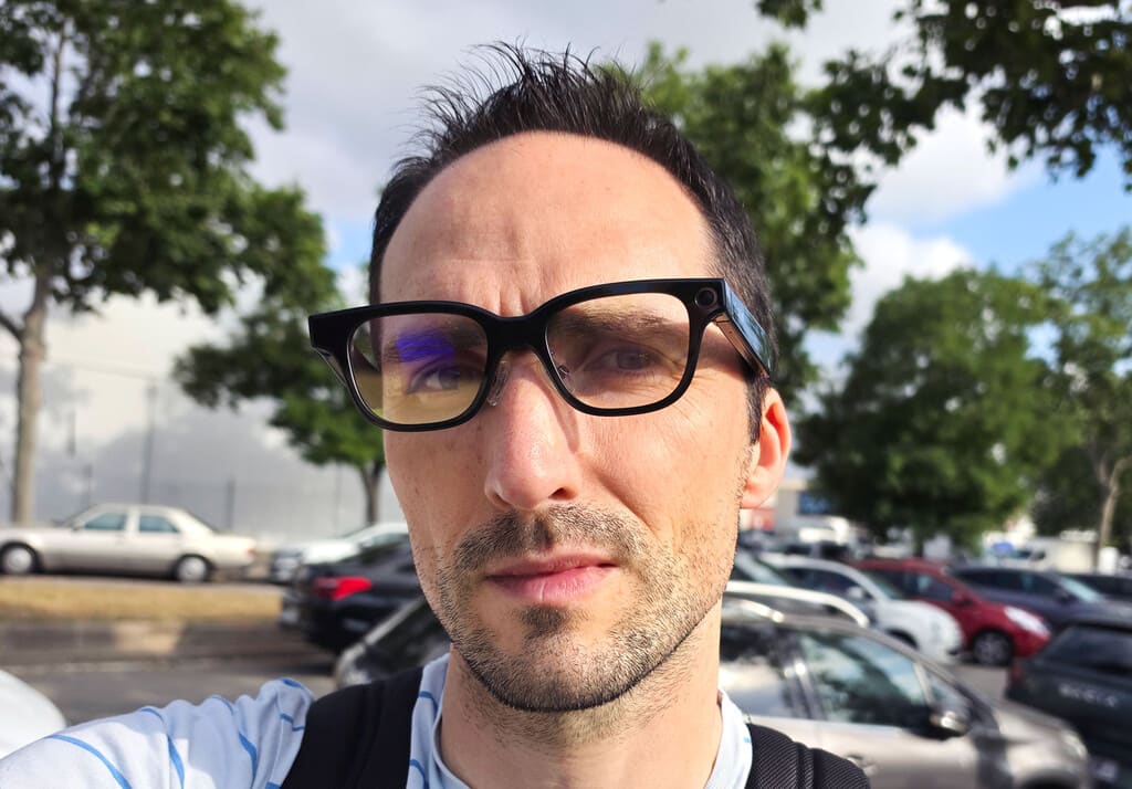 Primer plano de las Rokid AI Glasses puestas sobre una superficie neutra, mostrando su diseño elegante y la sutil lente verde emitiendo un brillo CRT.