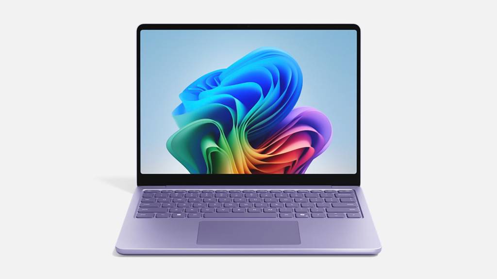 Un primer plano de dos portátiles Microsoft Surface con un diseño minimalista y moderno, uno abierto mostrando su pantalla y el otro cerrado, sobre un fondo gris neutro.