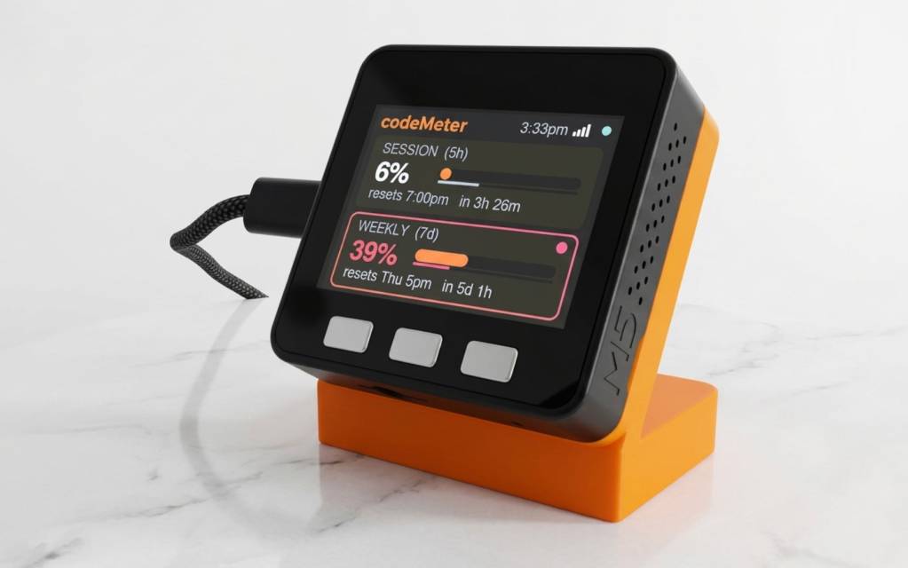Un pequeño dispositivo de escritorio con una pantalla digital mostrando un gráfico de consumo de cuota de Claude Code.