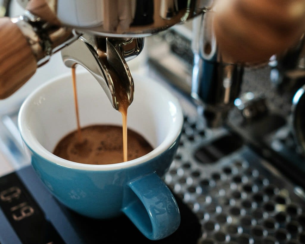 Concepto de tecnología ultrasónica aplicada a la preparación de café, con ondas sonoras abstractas interactuando con granos de café y agua.