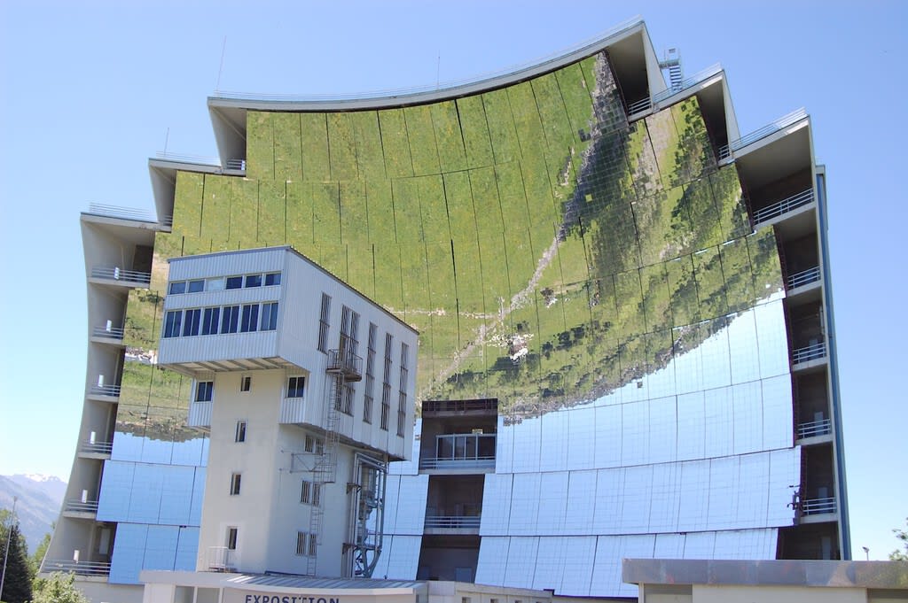 Vista exterior del horno solar de Odeillo en los Pirineos franceses, una gran estructura parabólica apuntando al cielo.