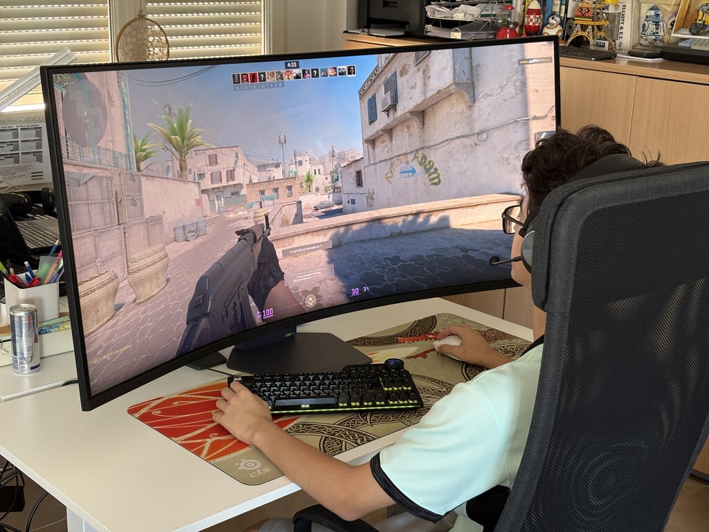 Monitor gamer LG UltraGear de 52 pulgadas con pantalla curva 1000R y resolución 5K2K, mostrando un paisaje futurista vibrante en juego.