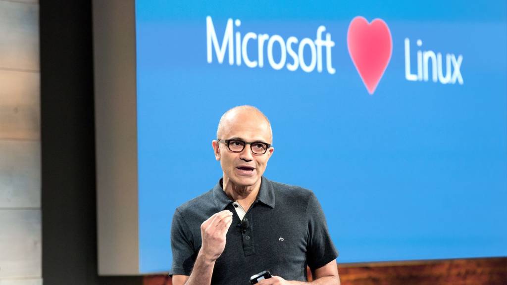Una representación abstracta de código binario fluyendo entre los logos de Microsoft y Linux, simbolizando su integración.