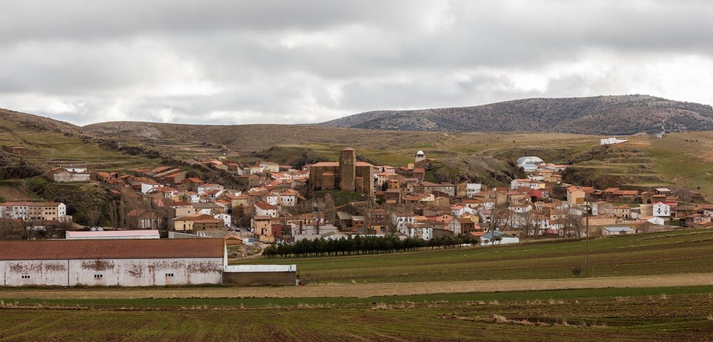 Vista panorámica de un pueblo español al atardecer con un cielo despejado y estrellas visibles, preparándose para un evento astronómico.