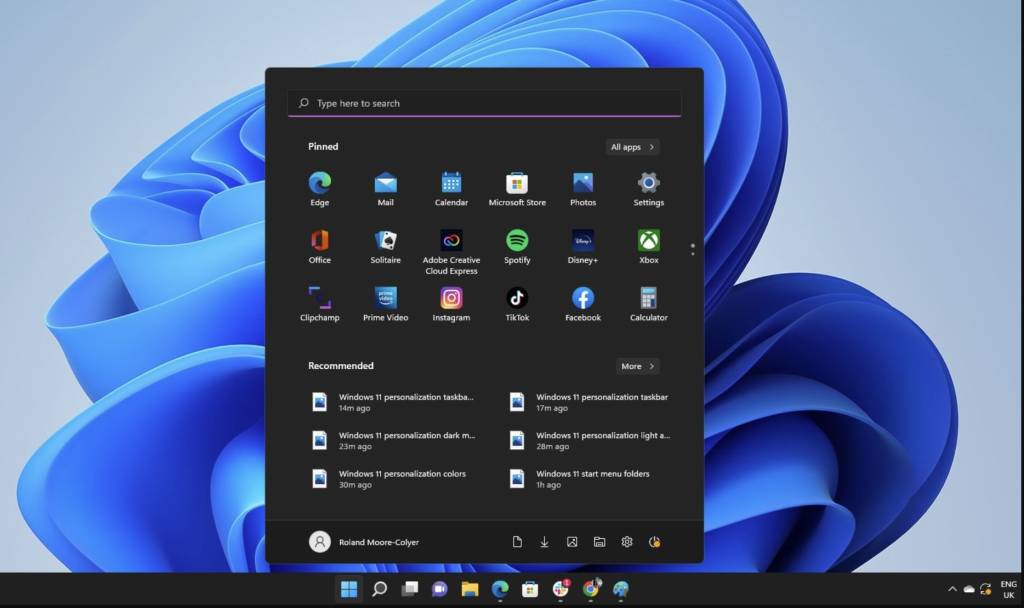 Un primer plano de un teclado de ordenador con el logo de Windows sutilmente visible, iluminado por un resplandor azul que sugiere tecnología y datos.