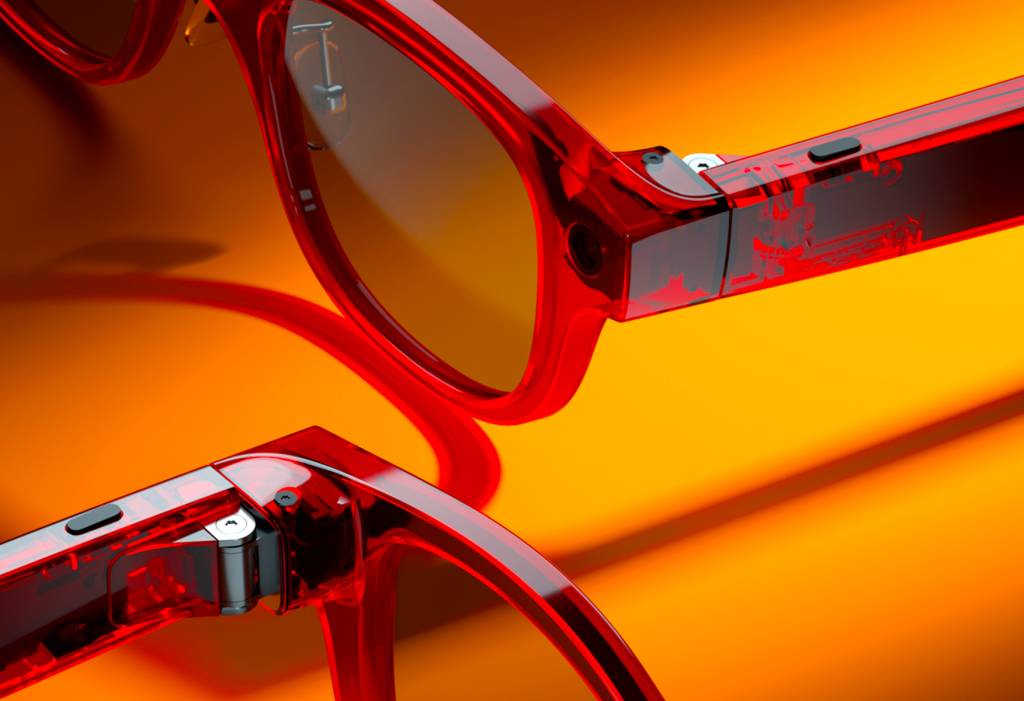 Un primer plano de unas gafas inteligentes modernas con un sutil reflejo tecnológico en las lentes, sobre un fondo limpio y profesional.